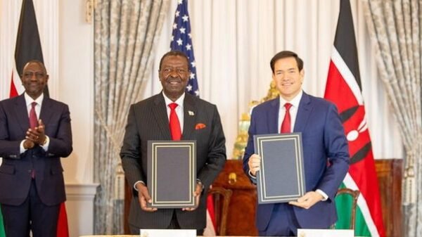 Kenya and United States officials hold signed trade agreement documents during bilateral meeting
