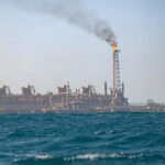 Offshore oil rigs at Senegal’s Sangomar field with sunset backdrop, representing record 2025 oil output